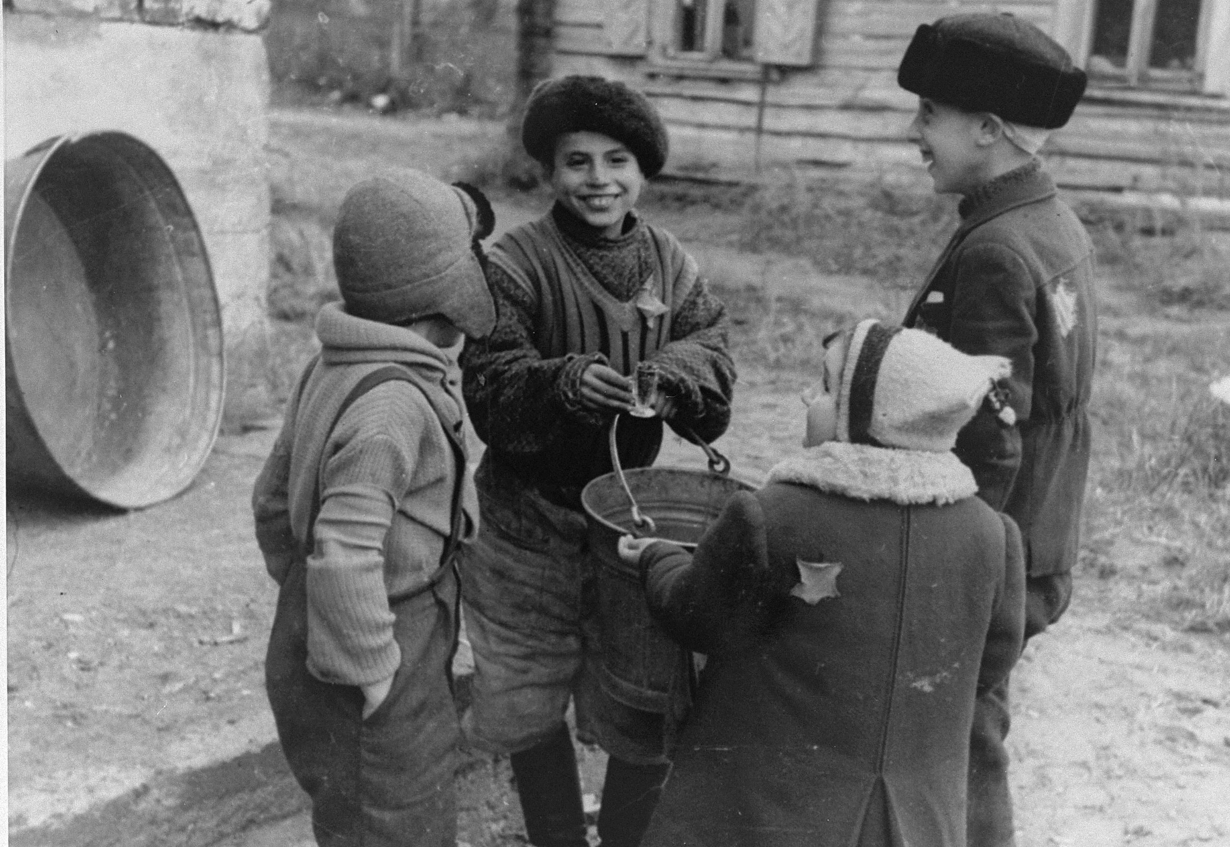 Quatre enfants juifs discutent dehors dans le ghetto de Kaunas. Photo: Georges Kadish (Crédit: USHMM)